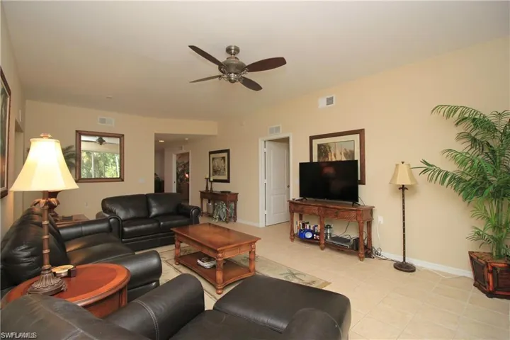 Living room with ceiling fan and light tile patterned floors