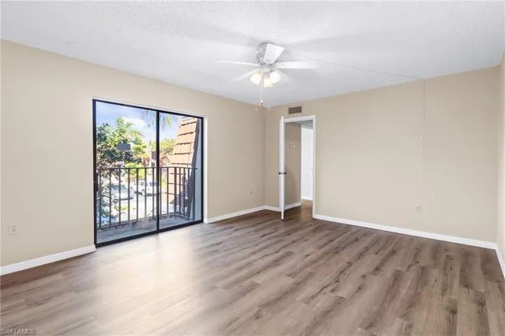 Empty room featuring hardwood / wood-style flooring, a textured ceiling, and ceiling fan