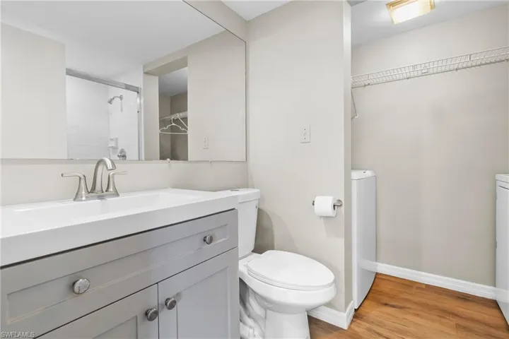 Bathroom featuring vanity, hardwood / wood-style flooring, a shower, and toilet