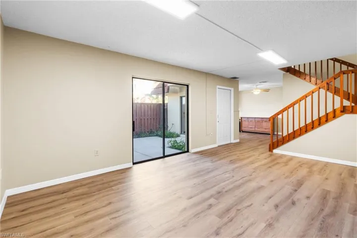 Unfurnished living room with ceiling fan, light hardwood / wood-style floors, and a textured ceiling