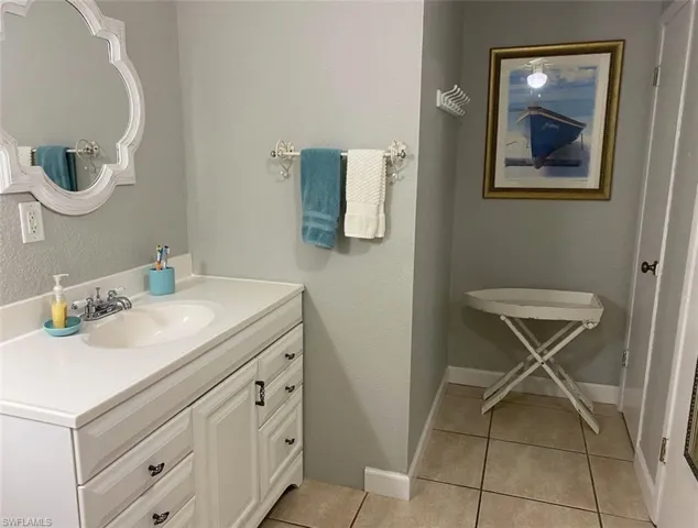 Bathroom featuring tile patterned floors, baseboards, and vanity