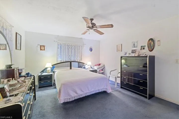 Carpeted bedroom featuring ceiling fan