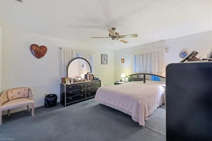 Bedroom featuring dark colored carpet and ceiling fan