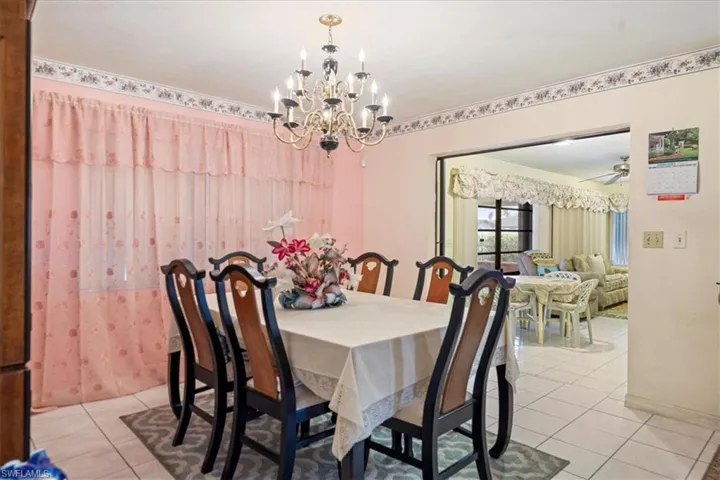 Tiled dining room with a chandelier