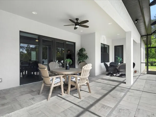 View of patio with a ceiling fan, outdoor dining area, and french doors