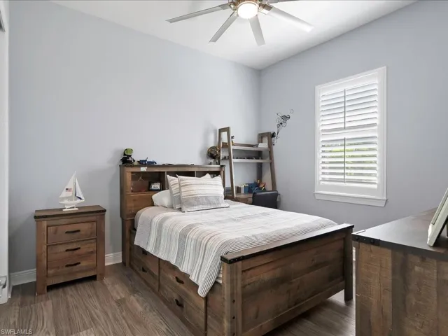 Bedroom featuring wood finished floors, a ceiling fan, and baseboards
