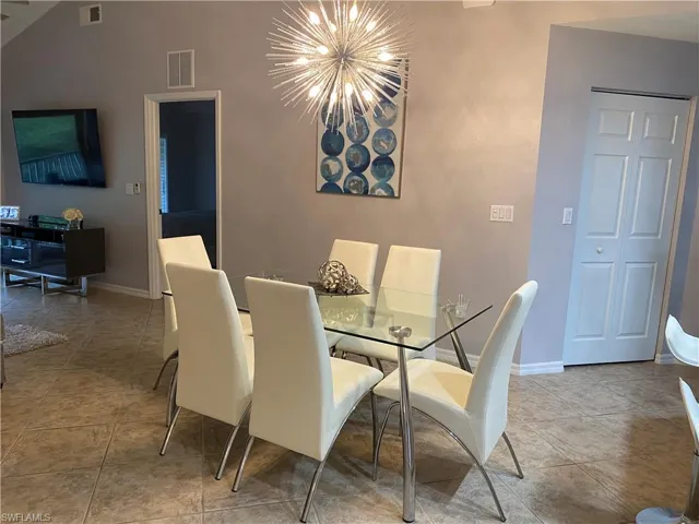 Tiled dining space with an inviting chandelier