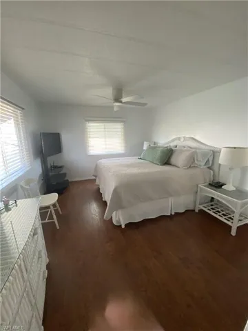 Bedroom with dark hardwood / wood-style flooring and ceiling fan