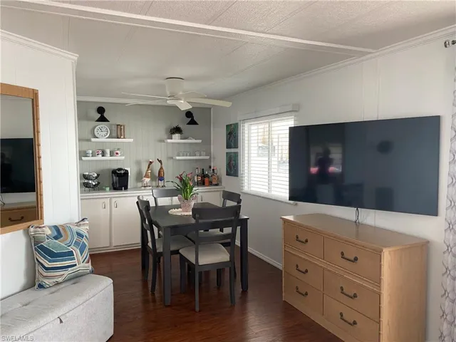 Dining room featuring ceiling fan, ornamental molding, and dark hardwood / wood-style floors