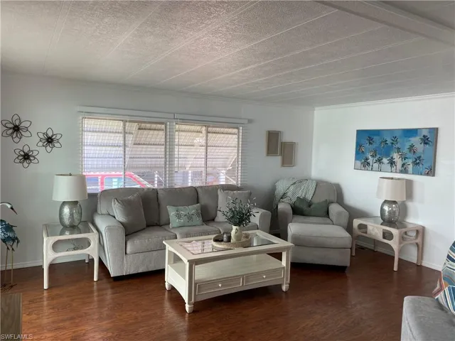 Living room with a healthy amount of sunlight and dark hardwood / wood-style flooring