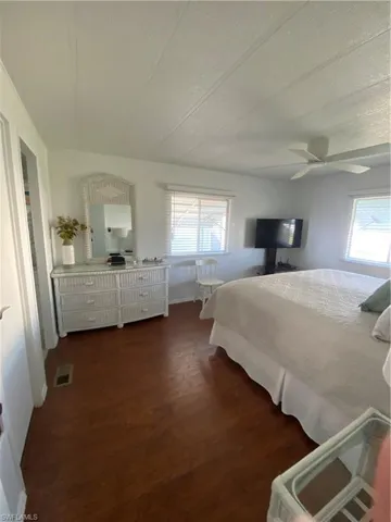 Bedroom with dark wood-type flooring and ceiling fan