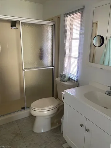 Bathroom featuring walk in shower, vanity, and toilet