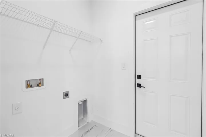 Laundry room featuring hookup for an electric dryer, washer hookup, and light marble finish flooring