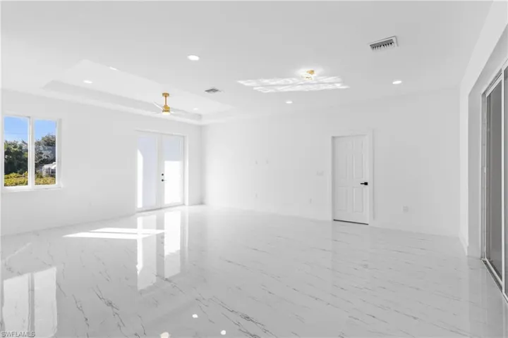 Spare room with light marble finish flooring, ceiling fan, recessed lighting, and a raised ceiling