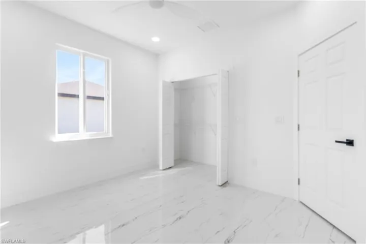 Unfurnished bedroom with light marble finish floors, a closet, ceiling fan, and recessed lighting