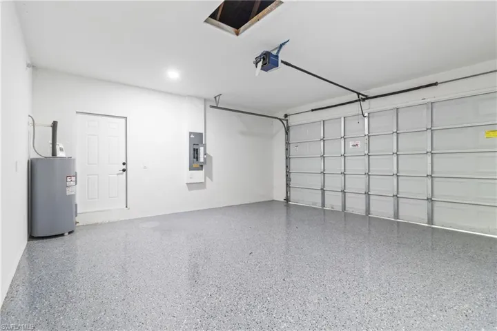 Garage featuring electric panel and a garage door opener