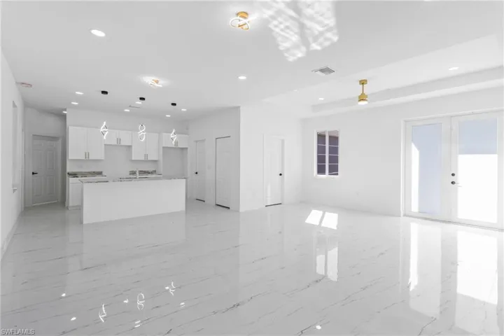 Unfurnished living room featuring recessed lighting and light marble finish flooring