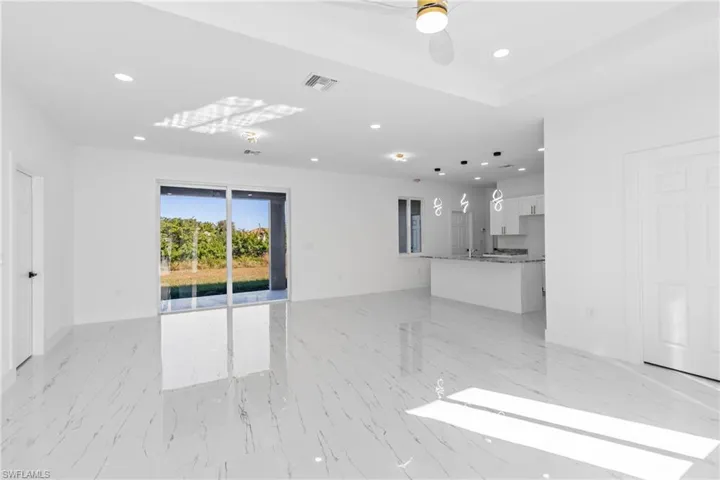 Unfurnished living room with recessed lighting, ceiling fan, and light marble finish flooring