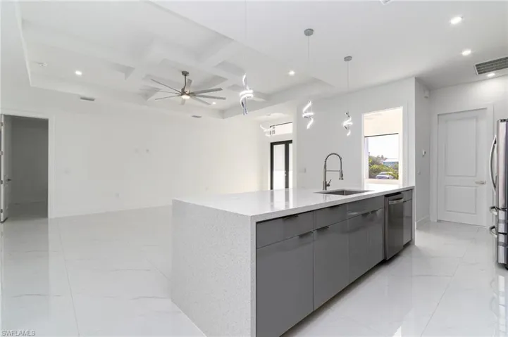 Kitchen with coffered ceiling, appliances with stainless steel finishes, a sink, gray cabinetry, and modern cabinets