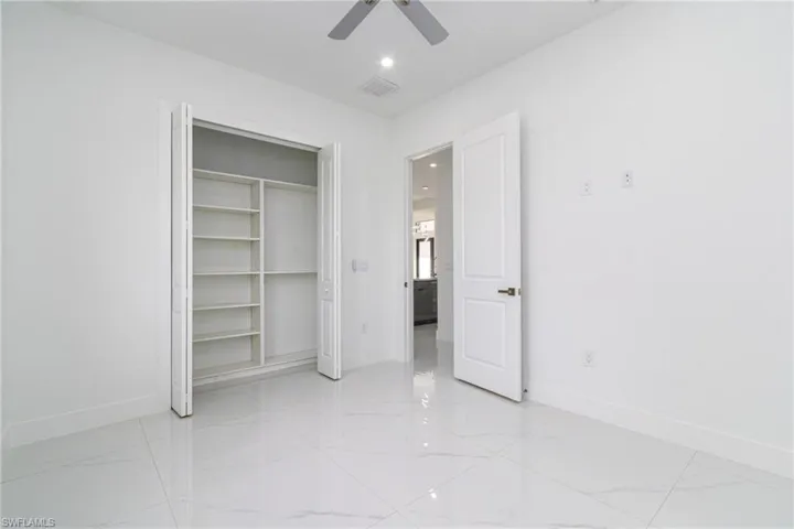 Unfurnished bedroom featuring baseboards, visible vents, a ceiling fan, and a closet