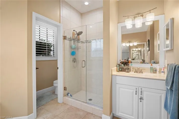 Bathroom with vanity, a stall shower, and light tile patterned floors