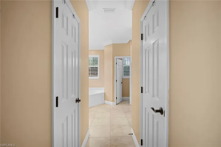 Corridor featuring light tile patterned floors and ornamental molding