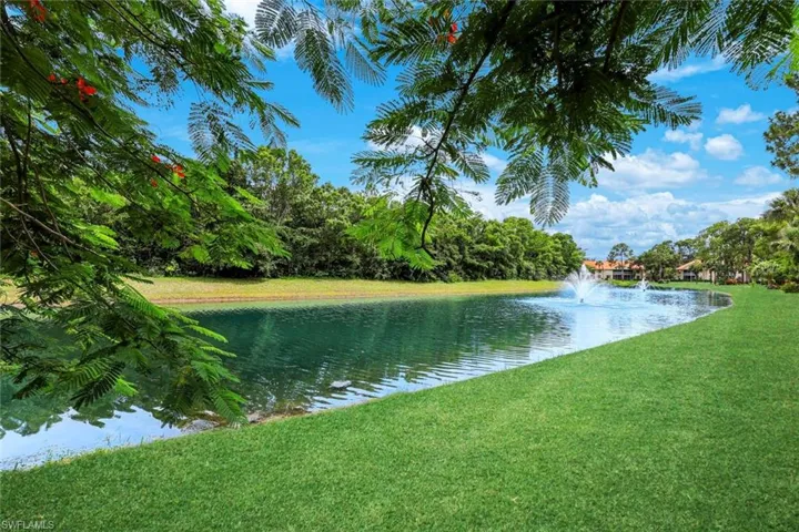 Expansive green lawn bordering a tranquil water feature with a fountain