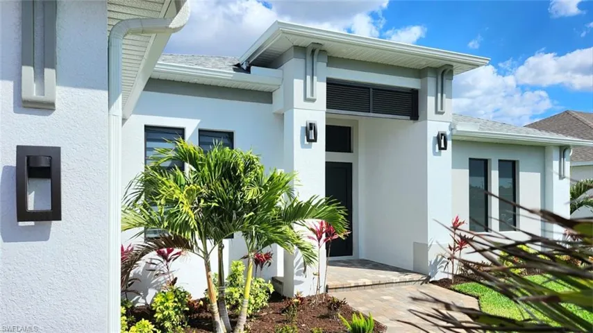 Entrance to property with stucco siding and roof with shingles