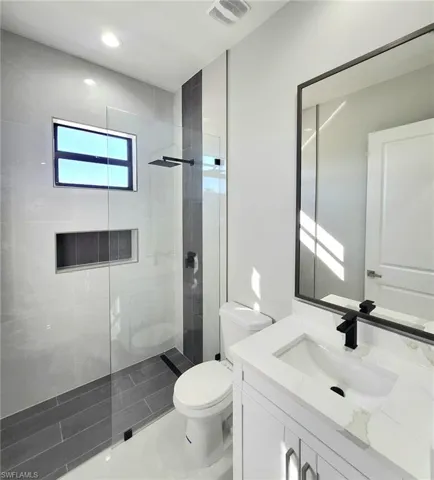 Bathroom featuring a walk in shower and vanity