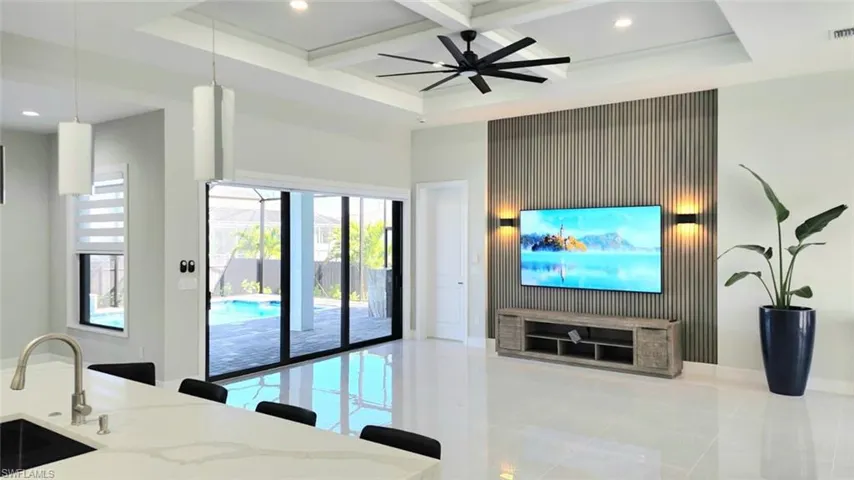 Living area featuring coffered ceiling, recessed lighting, a ceiling fan, light tile patterned flooring, and an accent wall
