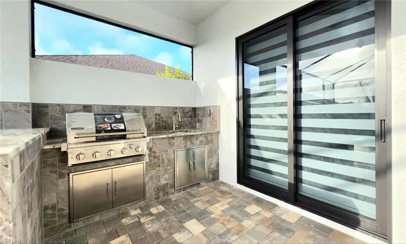 View of patio / terrace featuring beverage cooler and an outdoor kitchen