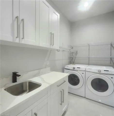 Laundry area featuring washer and clothes dryer and cabinet space