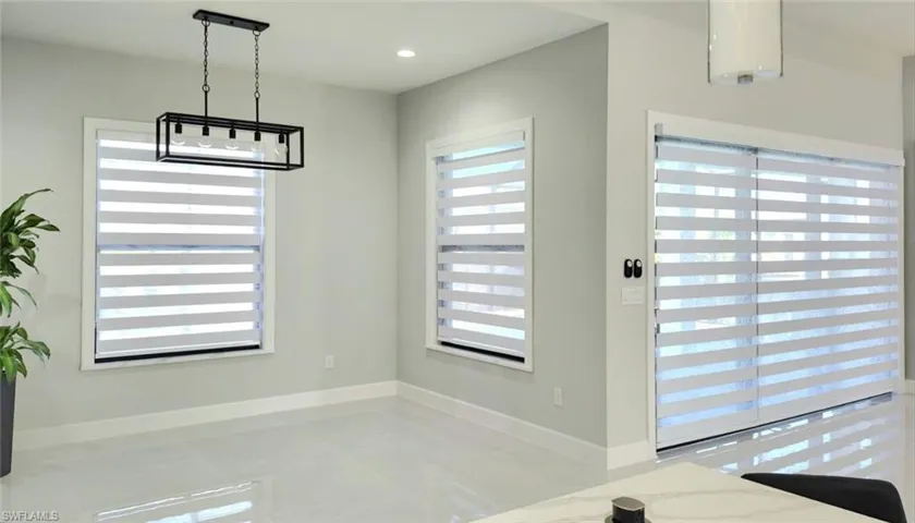 Unfurnished dining area featuring light tile patterned flooring and recessed lighting