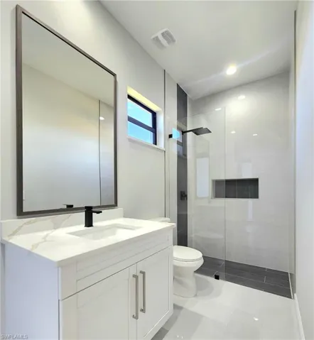 Full bathroom featuring vanity, a walk in shower, light tile patterned floors, and recessed lighting