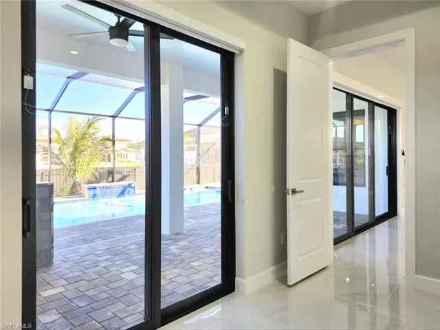 Doorway featuring a sunroom and a ceiling fan