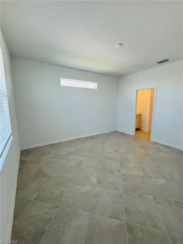 Spare room featuring a textured ceiling and a healthy amount of sunlight