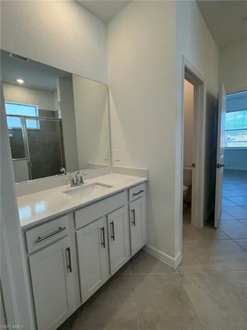 Bathroom featuring two seperate vanities and tile  flooring
