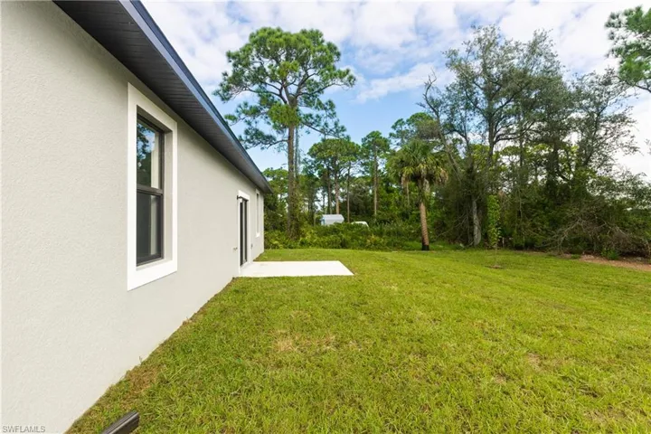 View of grassy yard featuring a patio