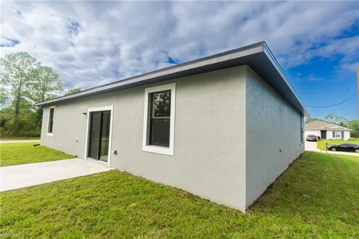 View of property exterior with a yard and stucco siding