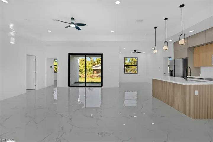 Kitchen with open floor plan, modern cabinets, ceiling fan, and healthy amount of natural light