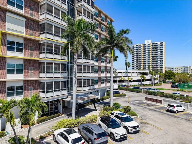 View of property with uncovered parking and a city view
