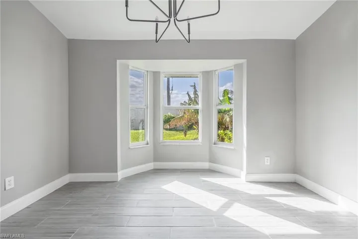 Unfurnished room with baseboards and a chandelier