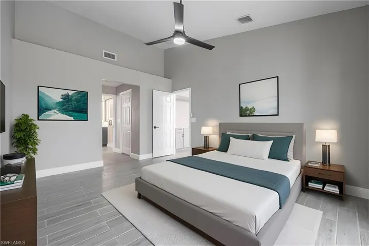 Bedroom with wood tiled floors, ceiling fan, and ensuite bathroom