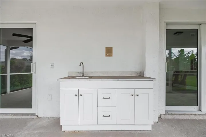 Bar with unfinished concrete floors and a sink