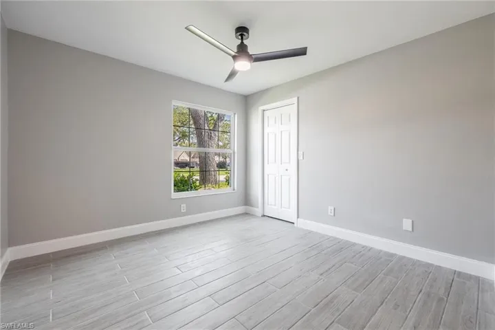 Spare room featuring baseboards, light wood-style flooring, and a ceiling fan