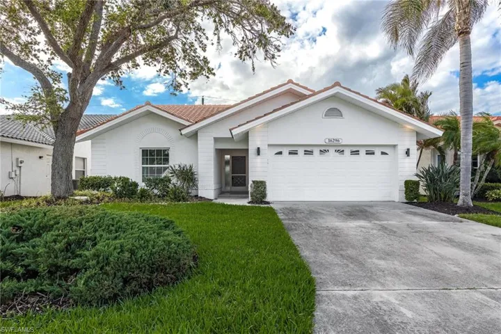 View of front of home featuring concrete driveway, stucco siding, an attached garage, a tiled roof, and a front yard
