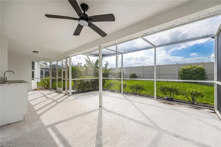 Unfurnished sunroom featuring a ceiling fan and a sink