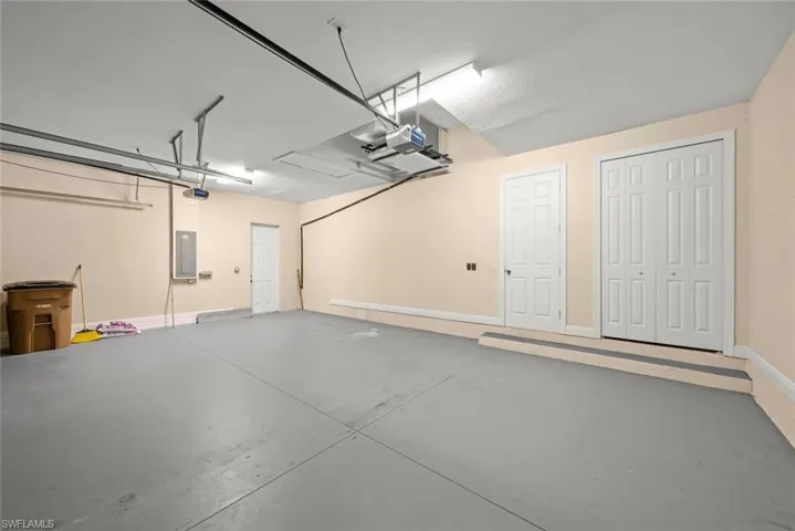 Garage featuring a garage door opener and electric panel