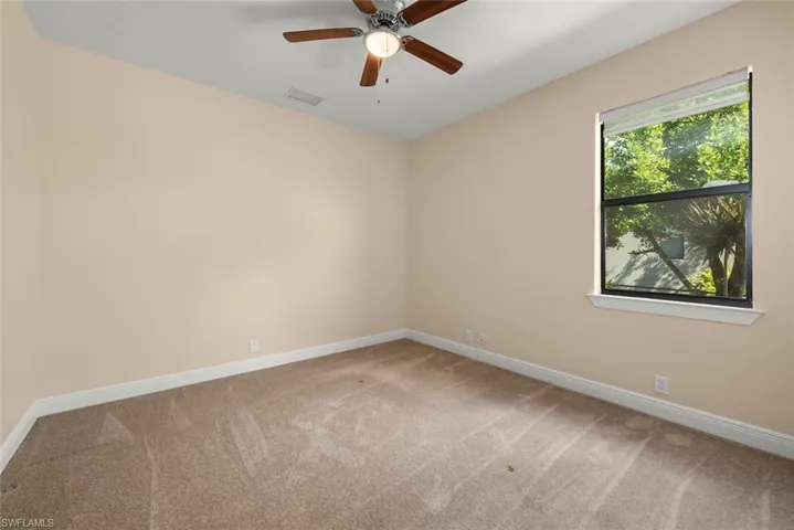 Carpeted spare room featuring ceiling fan