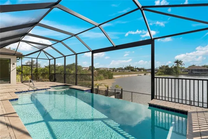 View of swimming pool featuring a water view, a lanai, a jacuzzi, and a patio area